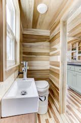 The bathroom walls display tongue-and-groove poplar siding with a light stain.&nbsp;