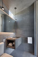 The architects outfitted the baths with smooth concrete floors, walls, ceilings—and a cantilevered vanity.