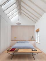 Whitewashed spruce rafters in the bedroom express the grain of the wood and serve as a canvas for light play.