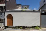 The stucco-clad tiny home is punctuated by archways, including the arched entrance, and two courtyards—one of which peeks out from beneath the cantilevered front facade.
