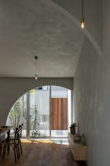 Lime plaster walls lend rich texture to the interior, absorbing and reflecting sunlight that pours in through an archway that frames the front courtyard.