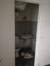 Gray tile on the floors and the walls created a dark and drab feeling for the existing bathroom.  Photo 10 of 15 in Before & After: This Hip Parisian Apartment Makes the Most of 193 Square Feet