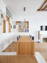 Petillaut designed a modernist built-in oak table that cantilevers in the dining room, preserving space in the open-plan area. Custom chairs with a slim silhouette also help to conserve space and create an airy quality for the room.