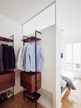 Bedroom, Bed, Wardrobe, and Light Hardwood Floor Petillaut designed a large closet on the other side of the partition wall, which also acts as a headboard for the bed, in one of the master bedrooms.  Photos from Budget Breakdown: A Muddled Parisian Pad Gets a Sleek Makeover for $117K