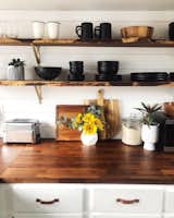 Wood counters from Ikea and live-edge salvaged wood shelves from Salvage Works in Portland add warmth and texture in the light-filled kitchen.