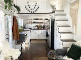 White-painted tongue-and-groove pine walls and a ceiling contrast with dark laminate floors, creating a bright and warm aesthetic for Katherine and Shelby's tiny home in Portland.