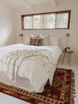 Hope painted the bedroom walls, ceiling and floor bright white, adding a fresh look and a feeling of spaciousness. "It's small," she says, "so I went with a simple bed frame and all-white linens to keep things light and bright."