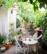 Whitney Leigh Morris and her son West sit at a bistro table in the side garden of their tiny cottage in Venice, California.