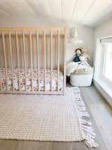 Emma arranged Ivy's room with a custom wood crib, a white-painted metal sconce, and a rug from HomeSense.