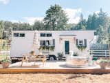The cedar-clad tiny house Emma McAllan-Braun and Joel Braun created with Mint Tiny Homes features a pine deck with a stock tank swimming pool. 