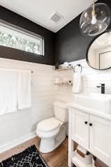 Shiplap, a wood vanity, and wood-style vinyl flooring lend texture and warmth in the bath.
