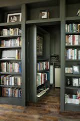 A minibar and storage area are hidden behind another section of the floor-to-ceiling bookshelves.
