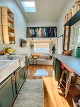 Kitchen, Laminate Counter, Open Cabinet, Wood Backsplashe, Colorful Cabinet, Drop In Sink, and Laminate Floor For now, the second sleeping loft functions as a closet.  Photos from Budget Breakdown: Two Travel Therapists Build a Tiny Home-on-Wheels for $24K