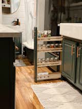 A narrow spice rack pulls out from the cabinetry and offers efficient storage in the kitchen.