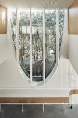 The wide upper portion of the arched window in the kitchen/dining space brings sunlight into the interior.