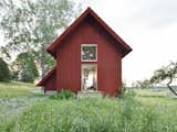 The compact home in Södermanland County, Sweden, that architect Per Söderberg designed for his family is clad with bright red board-and-batten siding.