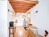 Kitchen, Wall, White, Quartzite, Microwave, Light Hardwood, Refrigerator, Cooktops, and Drop In The kitchen in The Sycamore features white-painted cabinetry, pine ceiling beams and flooring.  Kitchen Drop In Wall White Cooktops Photos from Book a Stay in This Whimsical Trio of Tiny Tree Houses