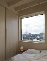 The bedroom, which is located on the third level, is finished with birch panels on the walls.