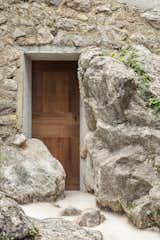 The teak front door of the existing house offsets the stone walls, lending warmth and texture.