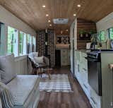 Living Room, Sofa, Medium Hardwood Floor, Ceiling Lighting, Chair, and Corner Fireplace You can follow Robbie and Priscilla’s converted school bus on Instagram at @going_boundless.  Photo 12 of 12 in 12 Inspiring Tiny Homes That Were Entirely DIY’ed