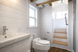 The bathroom is outfitted with a composting toilet and a large window. The designers placed storage beneath the stair treads that lead to the main bedroom.