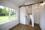 A sliding barn door closes off the main bedroom from the rest of the tiny home.