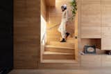 The oak staircase pivots as it leads from the bedroom on the top level to the living room on the second level.