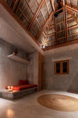A tall, thatched ceiling of dried palm leaves in the combined kitchen and living area facilitates natural ventilation.