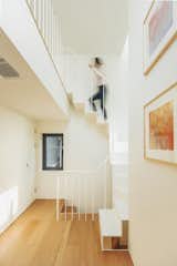 A white-painted steel-plate staircase leads from the third floor to the attic level.