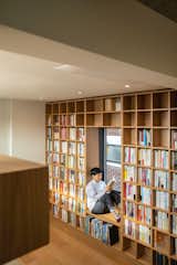 A wall on the second level features a built-in bookcase with a reading nook.