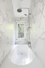 In the breezy bathroom, three walls are finished with white marble.