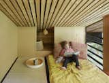 The guest bedroom, which is wrapped in wood, also features a built-in storage nook.