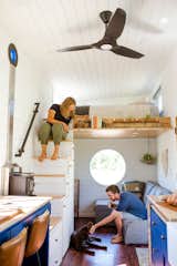 Sophia and Henry relax in the open-plan living area of their tiny home with their dog Cora, a Labrador retriever and Siberian husky mix.