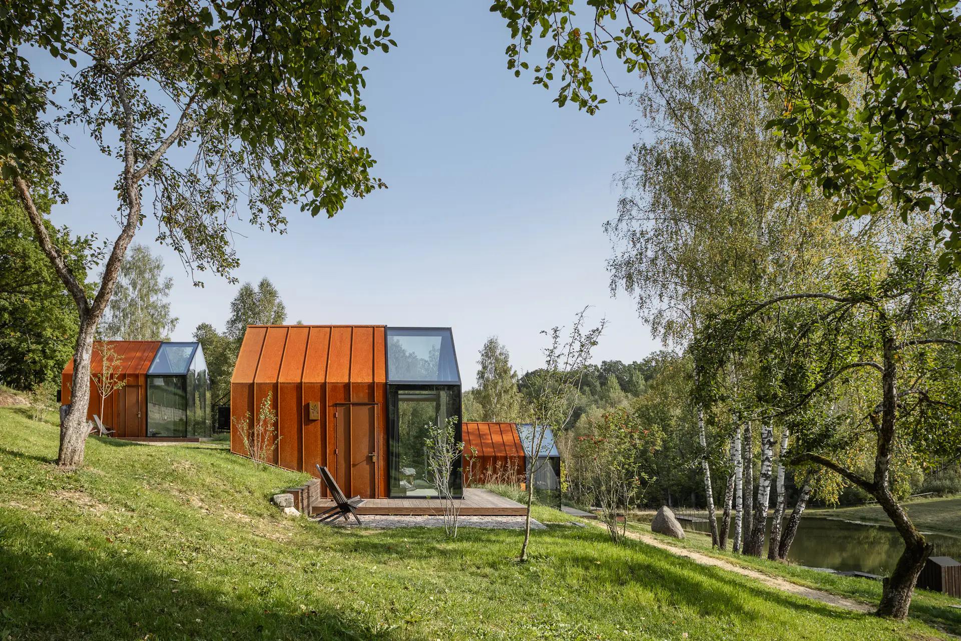 Nestled into a grassy hillside, the cabins overlook ponds and oak, birch, and linden trees that grow on the property.