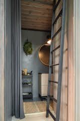 A steel ladder leads to a sleeping loft, and a bathroom is tucked into the steel-clad portion of each cabin. "The bathroom walls and floors are covered in a waterproof putty that has been treated with a matte varnish," Tetere-Sulce says. "This is a practical, durable solution for everyday use of the space."