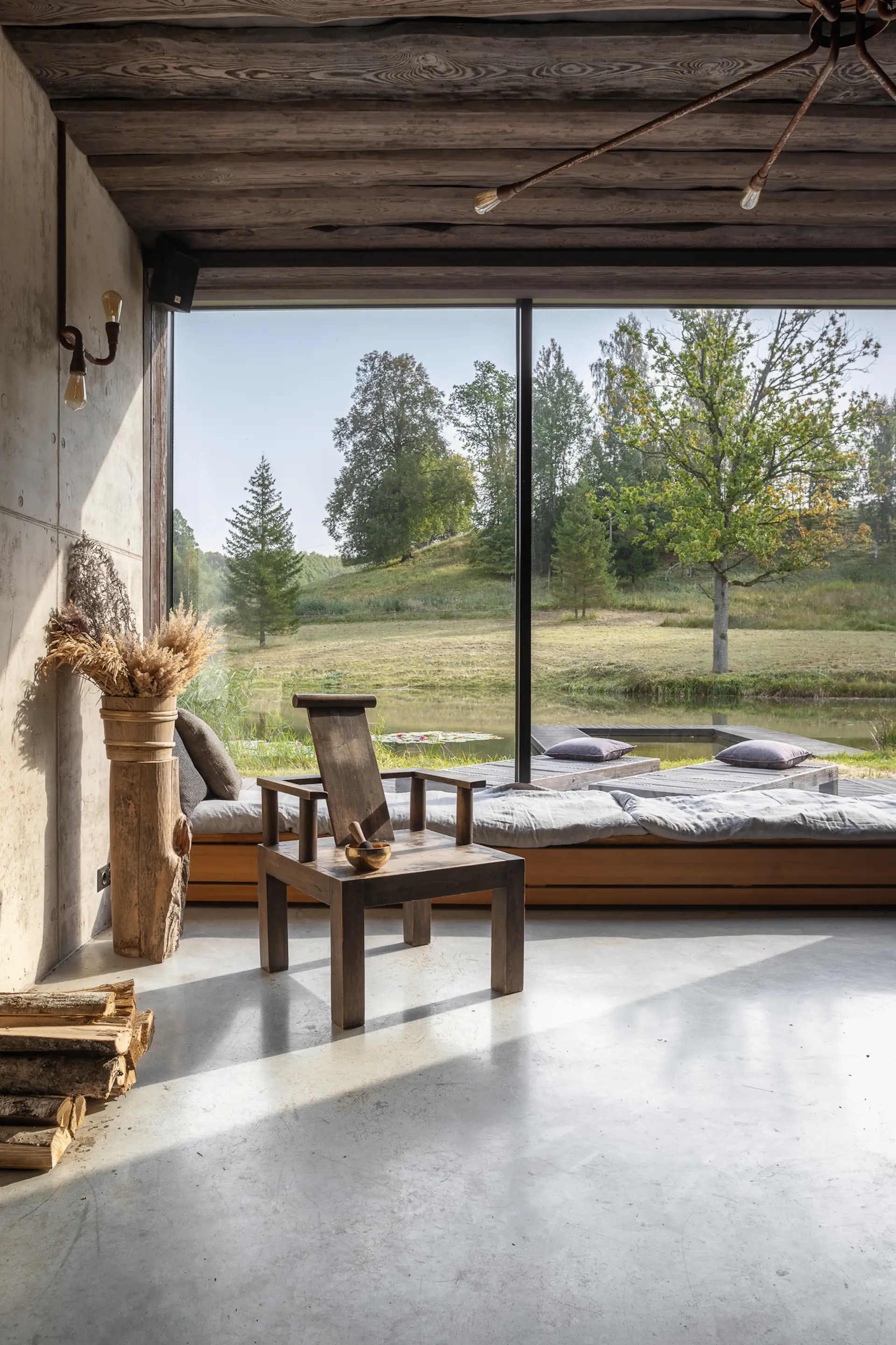 A low-slung, built-in bench runs along the expanse of glass in the sauna building, offering visitors a place to sit and ponder nature.