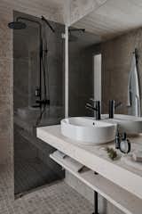 The bathrooms are outfitted with gray, stone-like tiles that reference the outdoors.