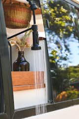 The kitchen faucet swivels through the sliding window and doubles as an outdoor showerhead.