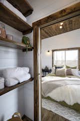 The linen closet is open to the main bedroom, where a pine ceiling provides warmth and texture.