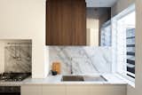 The kitchen displays a variety of textures, including dark walnut and marble.