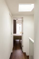 A skylight above the staircase floods the upper-level hallway with natural light.