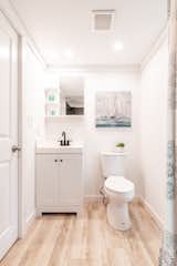 Bath Room, Light Hardwood Floor, Drop In Sink, Undermount Sink, Two Piece Toilet, and Ceiling Lighting The toilet in the bathroom offers a two-flush option that reduces water waste, while the off-grid package includes an incinerating toilet.  Photo 7 of 13 in This South Carolina Company Offers Tiny Cottages With Off-Grid Capabilities