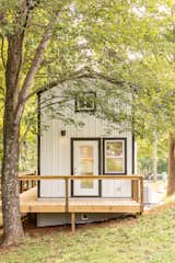 Exterior, Tiny Home, Gable, Metal, and Metal Black-painted window and door frames contrast with the white-painted steel siding and offer a crisp, clean aesthetic for the exterior of the cottage.  Exterior Tiny Home Photos from This South Carolina Company Offers Tiny Cottages With Off-Grid Capabilities