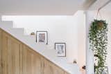The staircase that leads from the home’s first level to the upper-level art studio serves as a display area for artworks and features built-in storage.