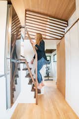 An stairway with alternating risers and built-in storage drawers accesses the loft-style bedroom. The flooring throughout the home is Douglas fir.