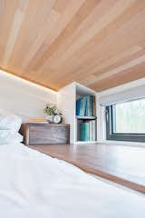 The Fritzes created built-in bedside storage in the loft area, where a Douglas fir ceiling provides warmth and texture.