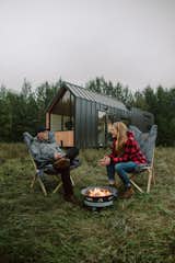 Kevin and Heather Fritz talk beside a fire pit in the front yard of the tiny home.