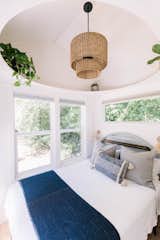 Bedroom, Bed, Ceiling Lighting, and Light Hardwood Floor A circular ledge in the main-floor bedroom creates interest, a feeling of airiness, and a place to store books, plants, and special objects.  Photo 4 of 9 in A Tiny Home in Washington Captures the Serenity of the West Coast