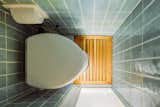 The Hunters created the bathroom as a wet room, where the shower head is arranged above the Nature's Head composting toilet. A slatted cedar ceiling and floor provide a spa-like sensibility for the space.