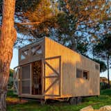 The wood-clad tiny home opens in the rear and connects to nature.